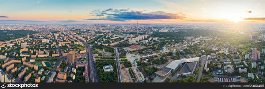 Aerial view of Moscow over the VDNKh and Cosmos hotel at summer sunset. There are distant Ostankino tower and Moscow City business center skyscrapers