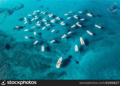 Aerial view of motorboats in shape of the heart on blue sea at sunset in summer. Travel in Sardinia, Italy. Drone view from above of speed boats, yachts, ocean, transparent azure water. Tropical