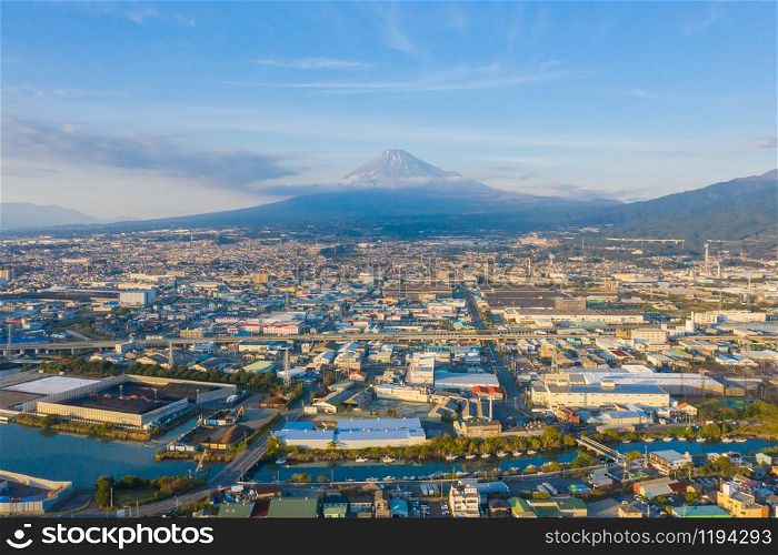 Aerial view of Mountain Fuji near industrial area, factory, Japanese port and harbour in Shizuoka City at sunset, Japan. Natural landscape background.