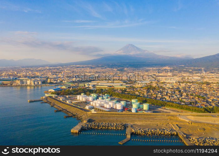 Aerial view of Mountain Fuji near industrial area, factory, Japanese port and harbour in Shizuoka City at sunset, Japan. Natural landscape background.