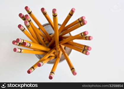 Aerial view of new orange HB pencils in holder, on white background.