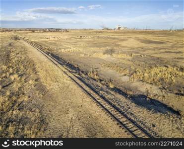 aerial view of northern Colorado landscape in fall or winter scenery - abandoned railroad, farmland, cattle, power station and oil extraction