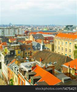 Aerial view of oldtown architecture with red tiled rooftops and modern cityscape in background, Brussels, Belgium