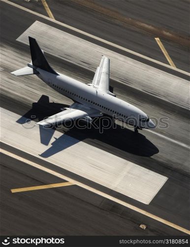 Aerial view of passenger airplane on airport runway.