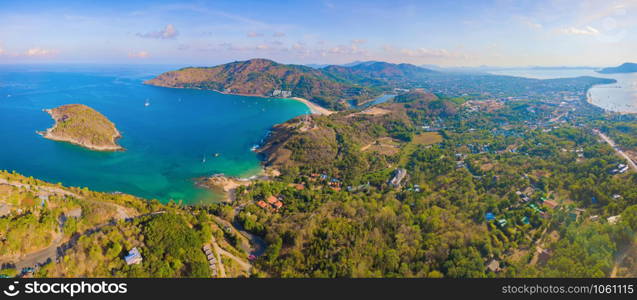 Aerial view of Patong beach with blue turquoise seawater, mountain hills, and tropical green forest trees with Andaman sea in Phuket island in summer, Thailand in travel trip. Nature background.