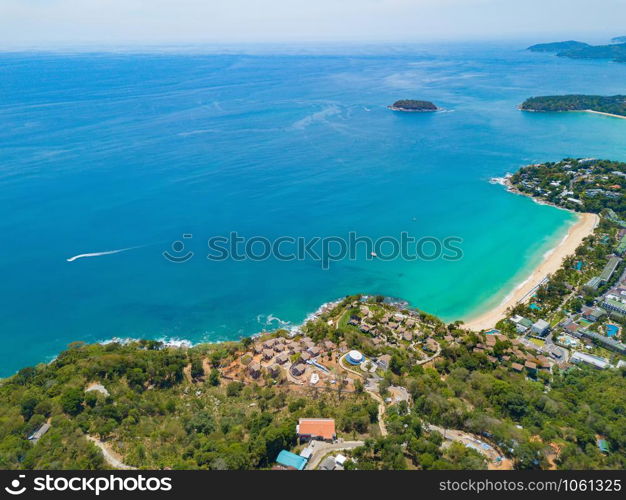 Aerial view of Patong beach with blue turquoise seawater, mountain hills, and tropical green forest trees with Andaman sea in Phuket island in summer, Thailand in travel trip. Nature background.