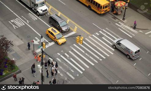 Aerial view of people walking across crosswalk of intersection