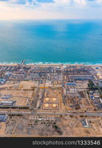 Aerial view of petrochemical oil refinery and sea in industrial engineering and energy concept in Dubai, urban city, UAE. Oil and gas tanks pipelines in industry. Modern metal factory. Power plant.