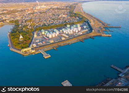 Aerial view of petrochemical oil refinery and sea in industrial engineering concept in Shizuoka district, urban city, Japan. Oil and gas tanks pipelines in industry. Modern metal factory.