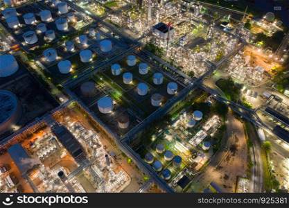Aerial view of petrochemical oil refinery and sea in industrial engineering concept in Bangna district at night, Bangkok City, Thailand. Oil and gas tanks pipelines in industry. Modern metal factory.