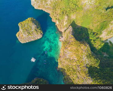 Aerial view of Phi Phi, Maya beach with blue turquoise seawater, mountain hills, and tropical green forest trees at sunset with Andaman sea in Phuket island in summer, Thailand in travel trip. Nature.