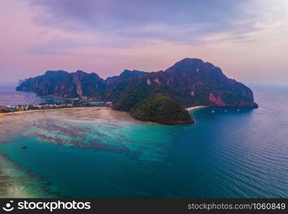 Aerial view of Phi Phi, Maya beach with blue turquoise seawater, mountain hills, and tropical green forest trees at sunset with Andaman sea in Phuket island in summer, Thailand in travel trip. Nature.