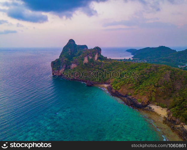 Aerial view of Phi Phi, Maya beach with blue turquoise seawater, mountain hills, and tropical green forest trees at sunset with Andaman sea in Phuket island in summer, Thailand in travel trip. Nature.