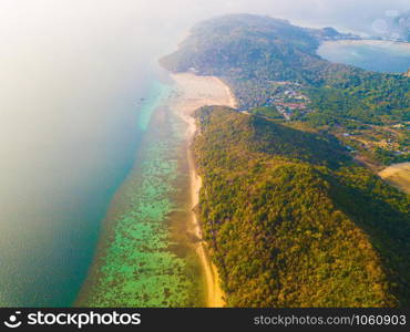 Aerial view of Phi Phi, Maya beach with blue turquoise seawater, mountain hills, and tropical green forest trees at sunset with Andaman sea in Phuket island in summer, Thailand in travel trip. Nature.