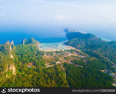 Aerial view of Phi Phi, Maya beach with blue turquoise seawater, mountain hills, and tropical green forest trees at sunset with Andaman sea in Phuket island in summer, Thailand in travel trip. Nature.