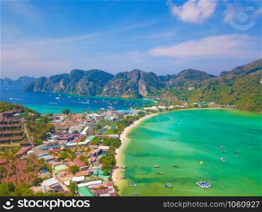 Aerial view of Phi Phi, Maya beach with blue turquoise seawater, mountain hills, and tropical green forest trees at sunset with Andaman sea in Phuket island in summer, Thailand in travel trip. Nature.
