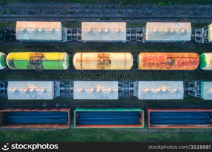 Aerial view of railway wagons. Cargo trains. Top view of colorful freight train on the railway station. Wagons with goods on railroad. Heavy industry. Industrial conceptual landscape. Transportation. Aerial view of railway wagons. Cargo trains