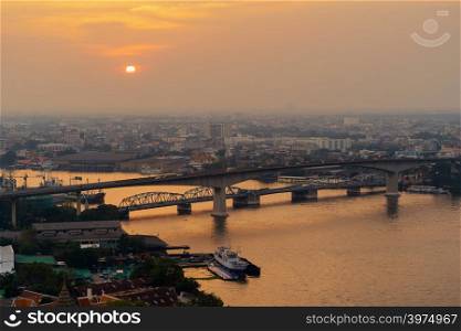 Aerial view of Rama 3 bridge and Chao Phraya River in structure of suspension architecture concept, Urban city, Bangkok. Downtown area at sunset, Thailand.