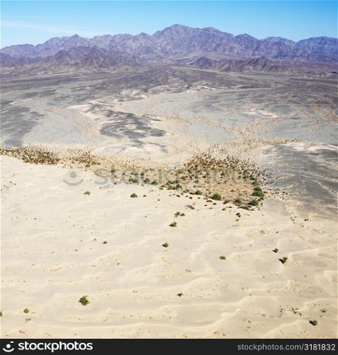 Aerial view of remote California desert with mountain range in background.