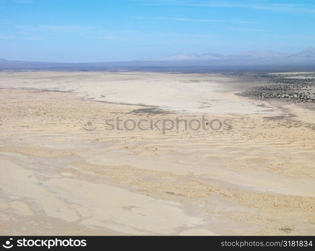 Aerial view of remote California desert with mountain range in background.