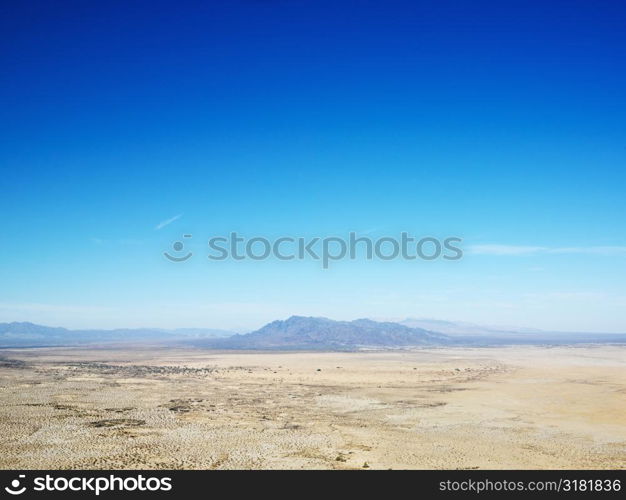 Aerial view of remote California desert with mountain range in background.