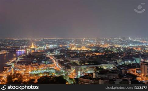 Aerial view of residential buildings and traditional temple in Rattanakosin Island, Bangkok downtown at night, Thailand. Urban city in Asia. Architecture landscape background.