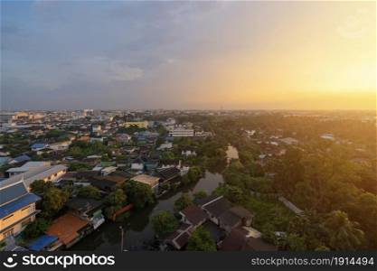 Aerial view of residential houses with nature trees, Wutthakat district, Bangkok City, Thailand in urban city in Asia. Residential houses, buildings at sunset.