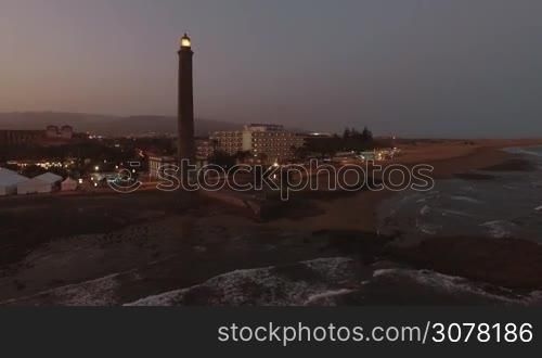 Aerial view of resort on the coast of Gran Canaria with Maspalomas Lighthouse at night. Active lighthouse of 19th century