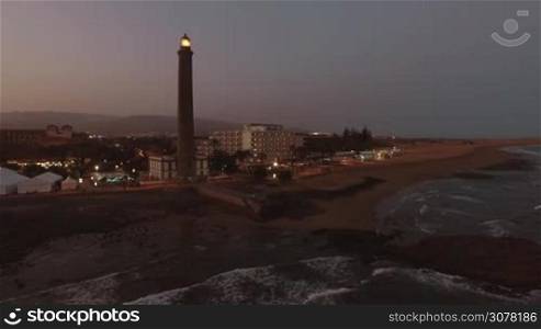 Aerial view of resort on the coast of Gran Canaria with Maspalomas Lighthouse at night. Active lighthouse of 19th century