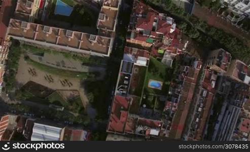 Aerial view of roofs of buildings and hotels with swimming pools, gardens, trees, Barcelona, Spain