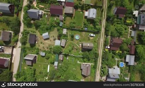Aerial view of Russian dacha community. Flying down to the children bathing outdoor pool near summer house. Moscow region, Ruza
