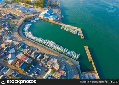 Aerial view of sail boats in marina port in harbor with blue turquoise seawater in urban city or town, Japan in travel trip and transportation concept. Top view.