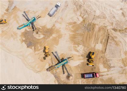 Aerial view of sand quarry with trucks and bulldozers. Heavy bulldozer loading sand,