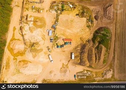 Aerial view of sandpit and factory plant producing sand materials for construction industry. Top view of large manufacturing plant in landscape