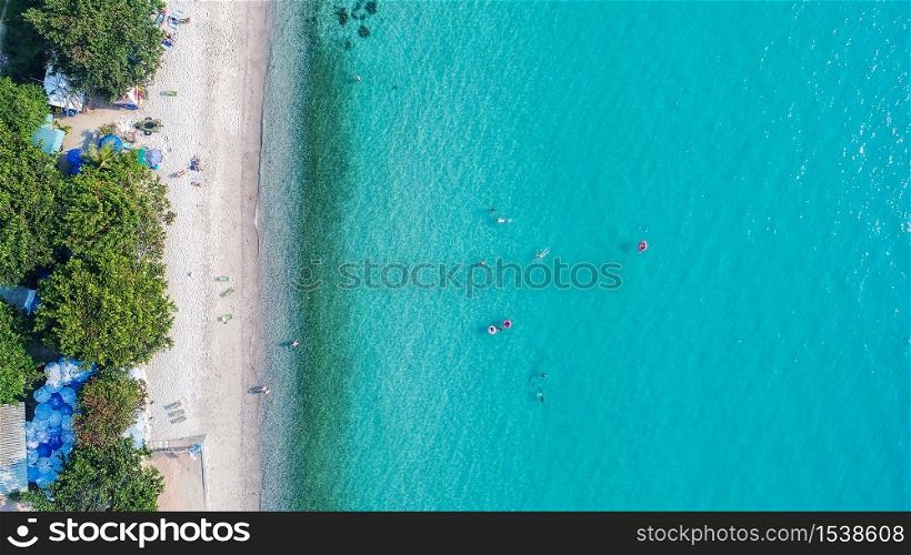 Aerial view of sandy beach with tourists swimming.