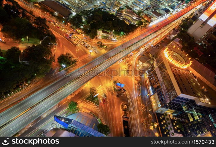 Aerial view of Sathorn intersection or junction with cars traffic, Bangkok Downtown. Thailand. Financial district in smart urban city and technology. Skyscraper office buildings at night