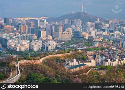 Aerial view of Seoul downtown cityscape and Namsan Seoul Tower on sunset from Inwang mountain. Seoul, South Korea.. Seoul skyline on sunset, South Korea.