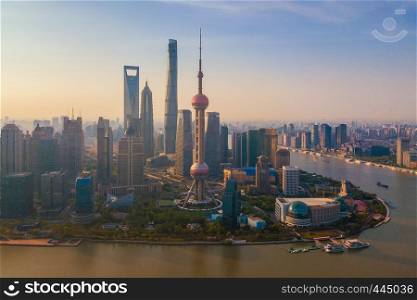 Aerial view of Shanghai Downtown, China. Financial district and business centers in smart city in Asia. Top view of skyscraper and high-rise buildings at sunset.