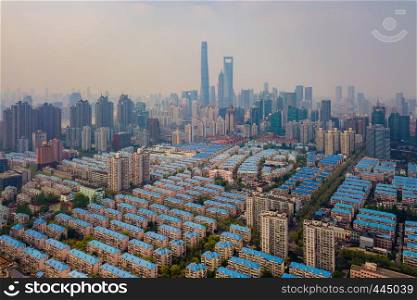 Aerial view of Shanghai Downtown, China. Financial district and business centers in smart city in Asia with residential houses. Top view of skyscraper and high-rise buildings at noon.