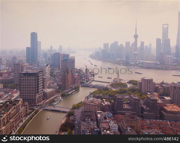 Aerial view of Shanghai Downtown, China. Financial district and business centers in smart city in Asia. Top view of skyscraper and high-rise office buildings at sunset.