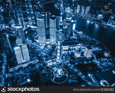 Aerial view of Shanghai Downtown, China. Financial district and business centers in smart city in Asia. Top view of skyscraper and high-rise buildings at night.