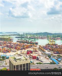 Aerial view of Singapore cargo shipping port, transportational containers, freight cranes in urban city area, seascape in background