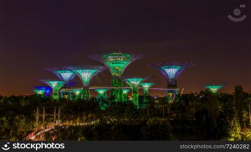 Aerial view of Singapore skyline is Modern buildings in the garden in night time.