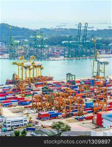 Aerial view of Singapore trade port, heavy equipment, cargo containers, freight cranes, docks and storages, harbor with ships and tankers