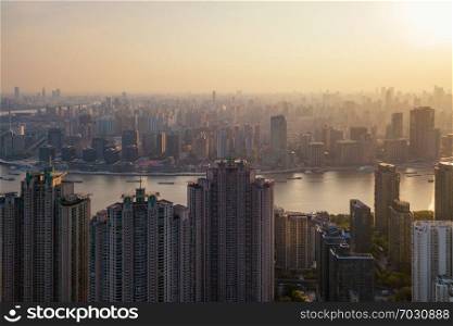 Aerial view of skyscraper and high-rise office buildings in Shanghai Downtown with Huangpu River, China. Financial district and business centers in smart city in Asia at sunset.
