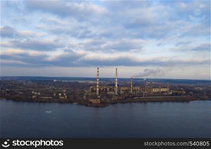 aerial view of smoke from the pipes of power plant station at the bank of a river