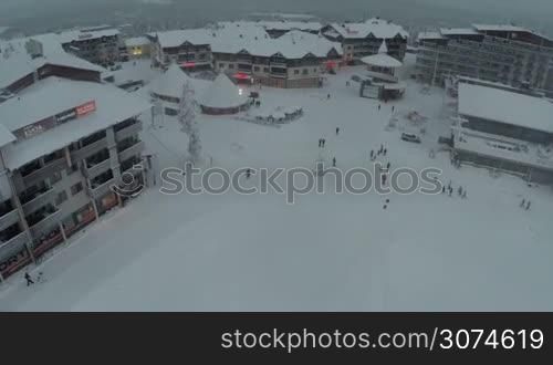 Aerial view of snowy territory of ski resort Ruka with hotels, restaurants and people walking around
