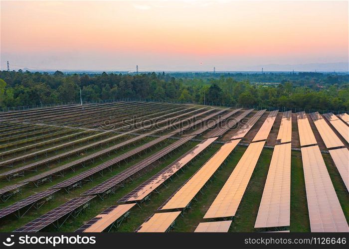 Aerial view of solar panels or solar cells on the roof in farm. Power plant with green field, renewable energy source in Thailand. Eco technology for electric power in industry.