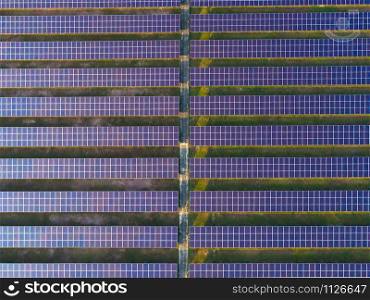 Aerial view of solar panels or solar cells on the roof in farm. Power plant with green field, renewable energy source in Thailand. Eco technology for electric power in industry.