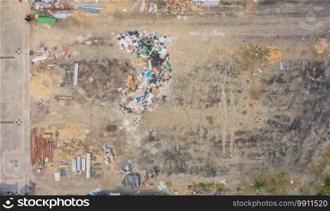 Aerial view of stack of different types of garbage pile, plastic bags, and trash withempty site in industrial factory in environmental pollution. Waste disposal in dumping site.